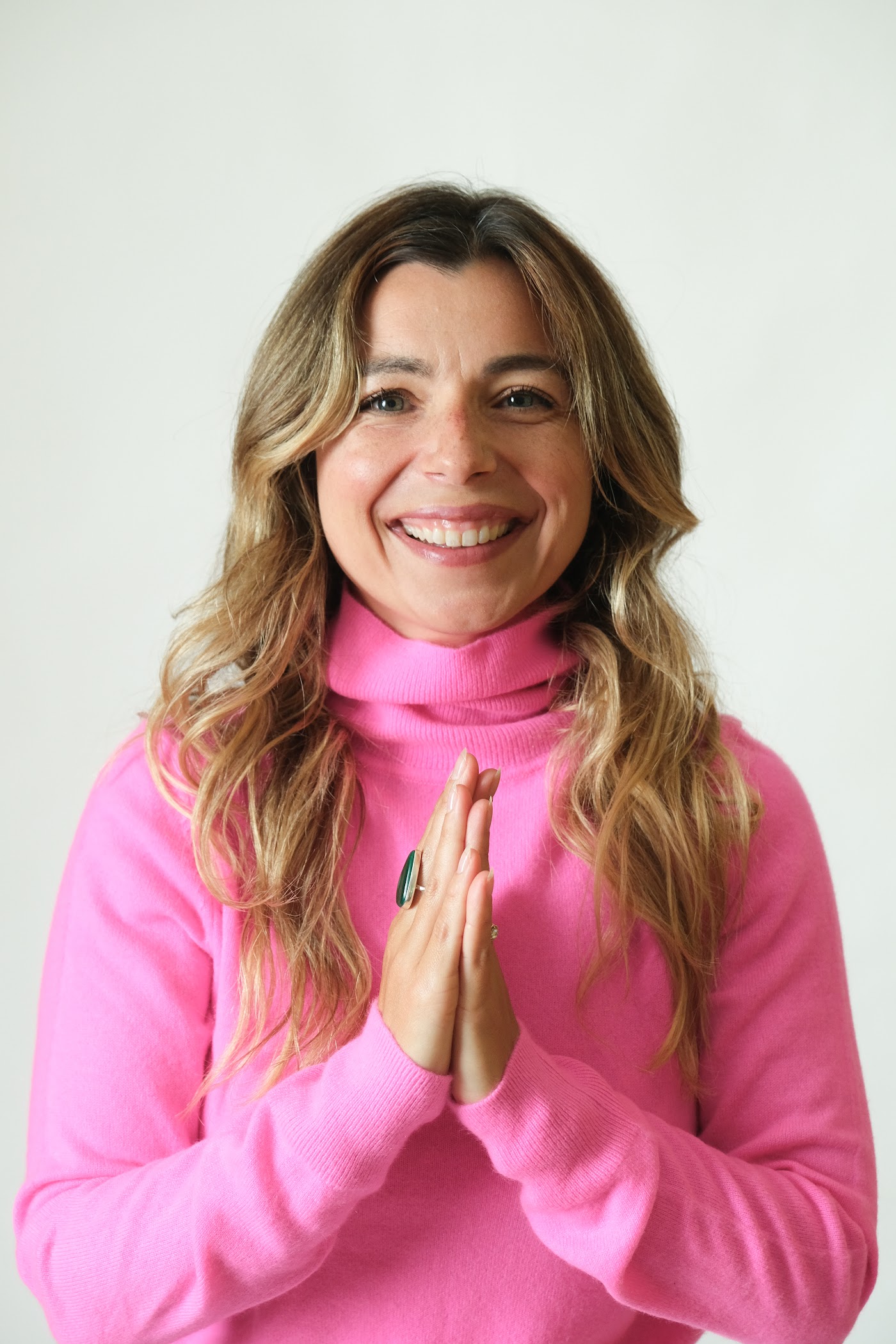 Simone smiling, wearing a pink sweater