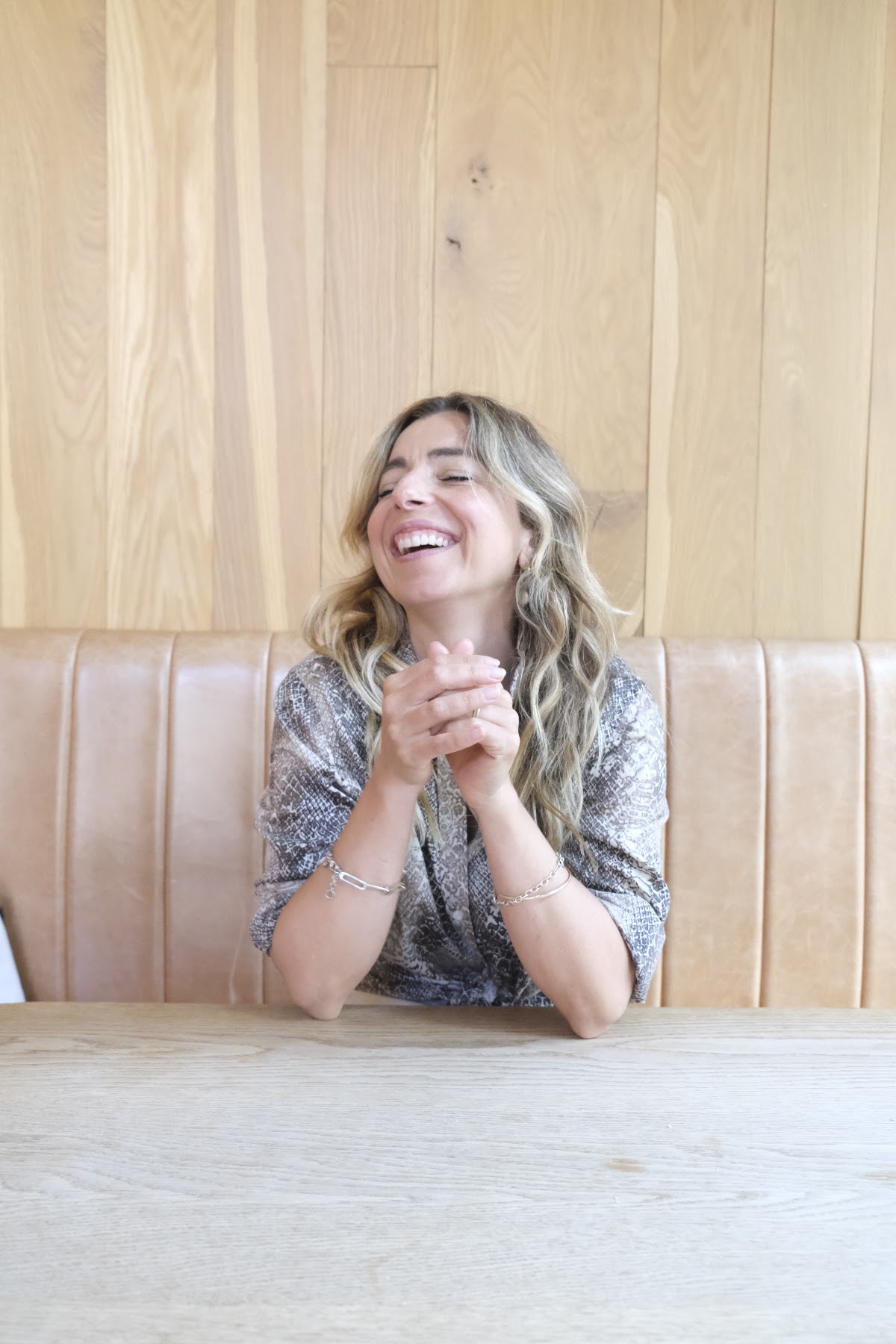Simone laughing at a café table